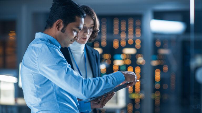 In Technology Research Facility: Female Project Manager Talks With Chief Engineer, they Consult Tablet Computer.