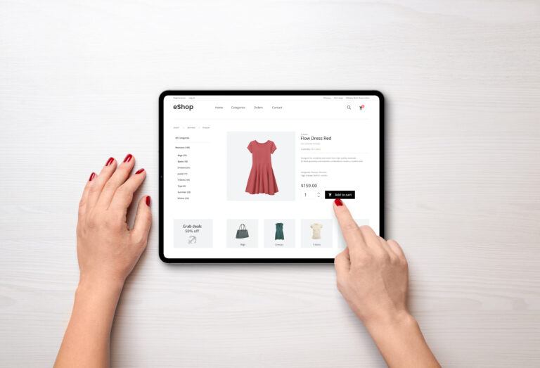 Online shopping with a tablet. Red women's dress on the e-commerce web page