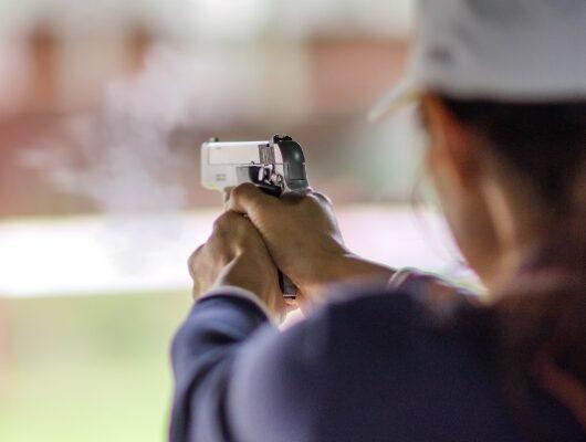 gun holding in hand of woman in practice shooting in martial arts for self defense in an emergency case