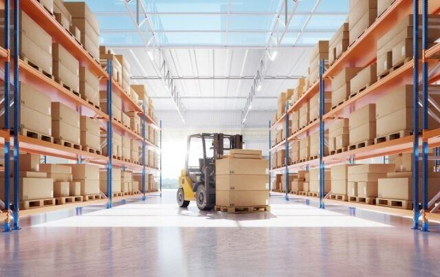 forklift in middle of warehouse with shelve of boxes