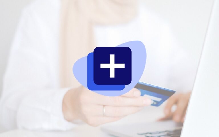 Woman in white shirt holding credit card with open laptop