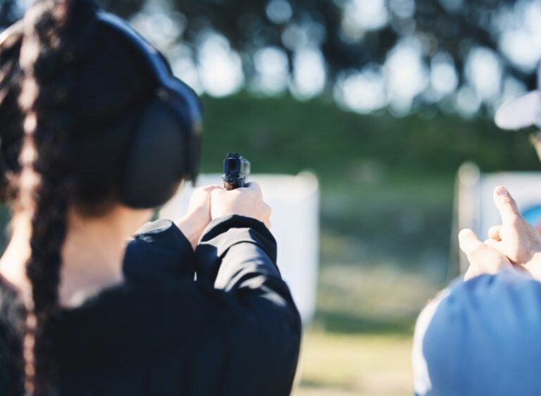 woman shooting gun at target outside