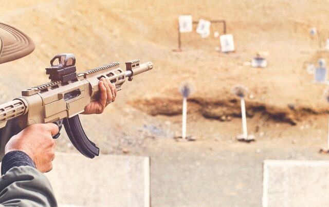 Men practicing shooting with a assault rifle at target. BigCommerce FFL BigCommerce Excise Tax Management