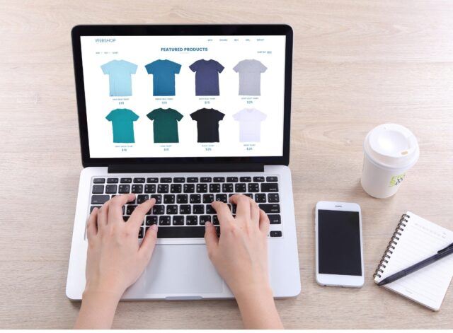 person on laptop browsing tshirts - view of hands only on laptop - BigCommerce SEO