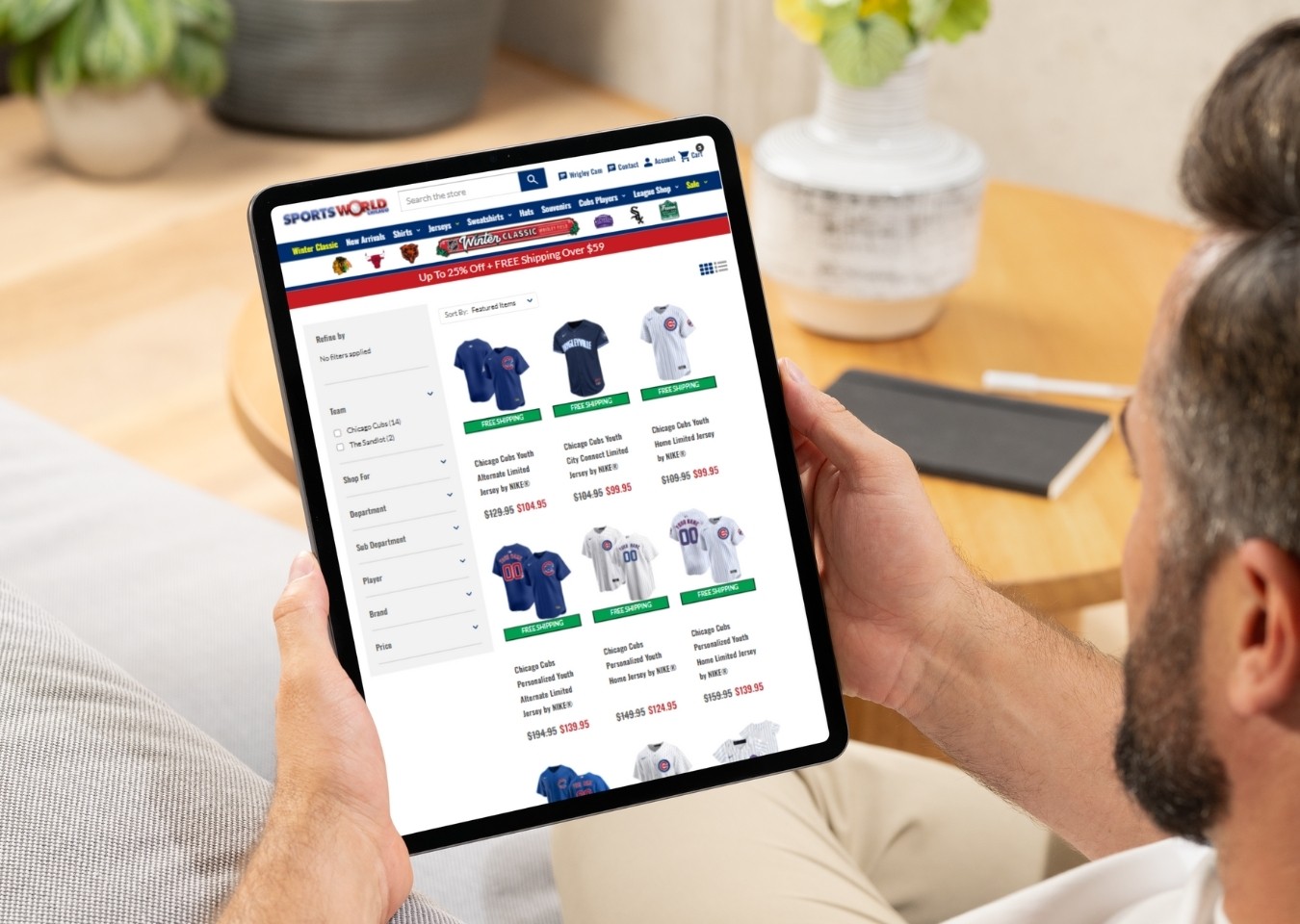 Man viewing tablet with category page for SportsWorldChicago.com showing on screen