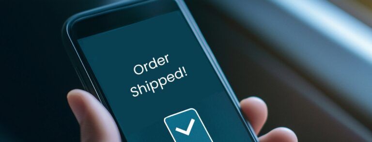 Closeup of hand holding cell phone with "Order Shipped" notification on screen