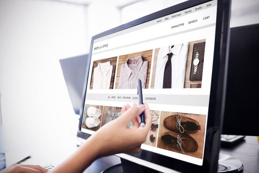 desktop view of fashion shop - person point at screen with stylus - Migrate to Shopify