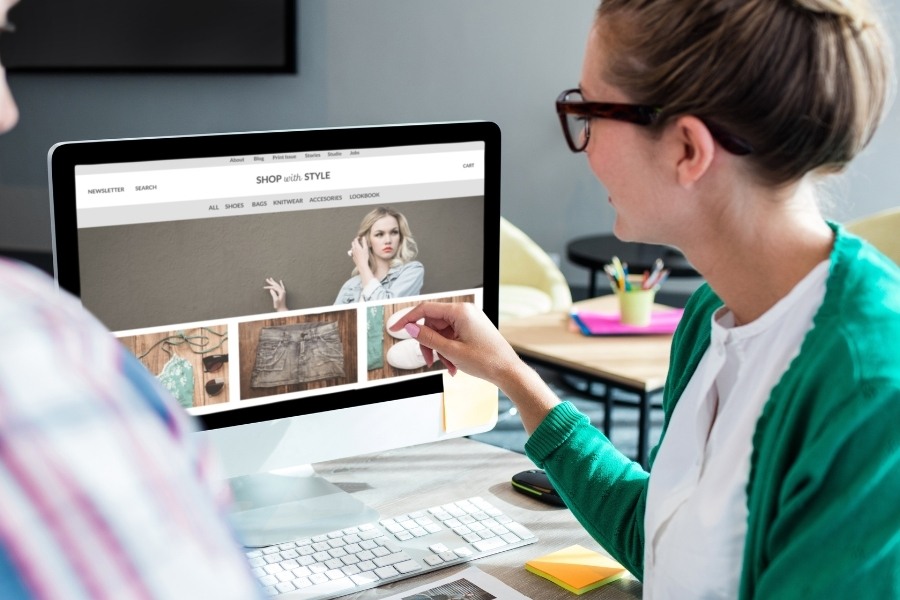 woman pointing at laptop screen showing ecommerce fashion shop - Shopify CRO services