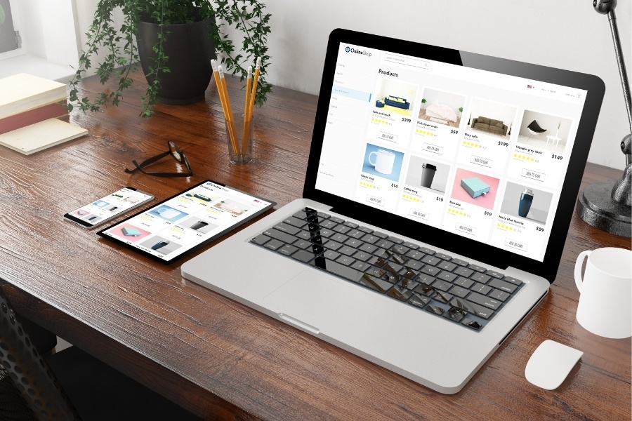 ecommerce shop open on laptop with tablet and mobile on desk - Shopify Headless Development